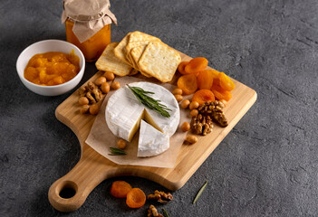 Brie cheese with nuts, pear slices and dried apricots. Camembert cheese. Brie cheese or Camembert...