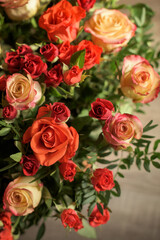 Bouquet of red, orange and yellow roses- a composition of multi-colored flowers. Background for a postcard.