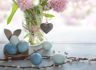 Spring easter decoration with pink flowers and pastel blue eggs. Space for text. Close up with...