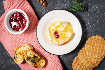 Delicious beautiful baked camembert with honey, walnuts, herbs and cranberries
