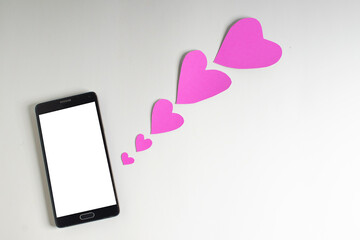 Smartphone and hearts paper on
 White background. Valentine or Sending love through social networks.