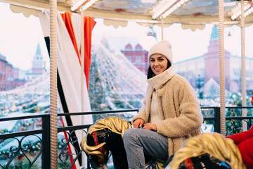 Happy woman enjoying Christmas carousel
