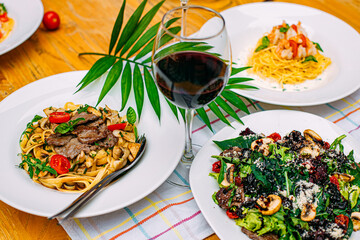 Served table with Italian pasta and salad on a decorated table