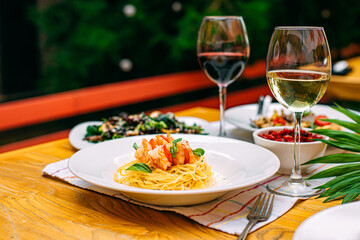 spaghetti with shrimps and tomatoes on a decorated table