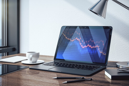 Laptop on table with market crash statistics on computer screen.