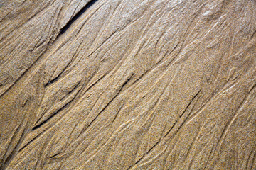 Close up of patterns on the sand from sea water after low tide, Spain