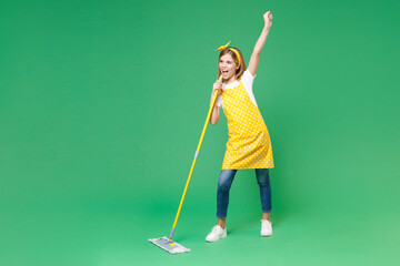 Full length funny little kid girl housewife 12-13 in apron sing song in mop like microphone dancing...