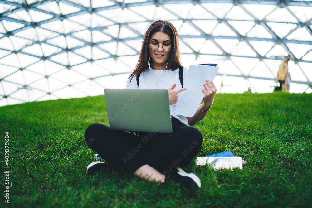 Poster caucasian female student in eyewear analyzing paper report during web conversation for discussing e 
