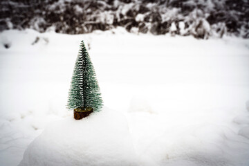 Artificial fir tree on snow background,