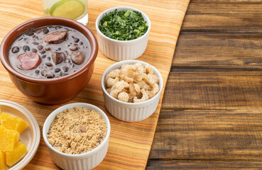 Traditional brazilian feijoada with manioc flour, kale, caipirinha and copy space