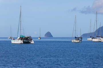 Fototapeta premium The catamaran and sailboats anchored in waters of caribbean beach.