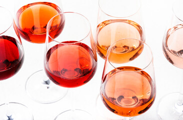 Rose wine glasses set on wine tasting. Degustation different varieties, colors and shades of pink wine concept. White background, top view