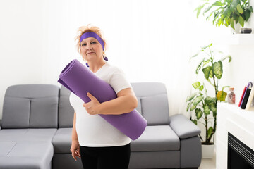 Photo of happy elderly woman with yoga mat after training