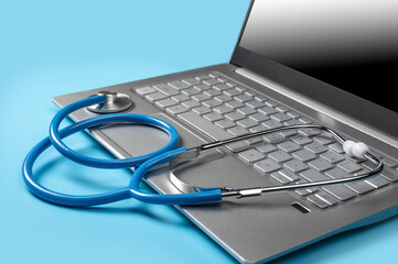 Stethoscope On Laptop Keyboard. Online doctor consultation, Healthcare and medical. Laptop diagnosis with stethoscope on blue background