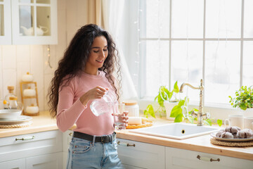 Young Beautiful Woman Drinking Water In Kitchen At Home