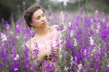 Sexy elegant woman on the meadow of flowers. Beautiful female outdoors. Freedom concept