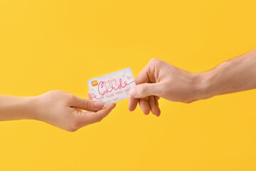 Hands with gift card on color background