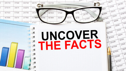 Notepad with inscriptions UNCOVER THE FACTS on a white background. business concept.