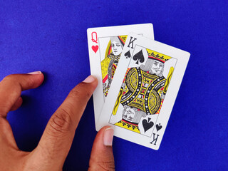 Queen of heart and king of spade playing cards on blue background