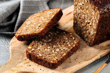 Fototapeta na wymiar Closeup on sliced rye whole grain bread with seeds on the wooden board