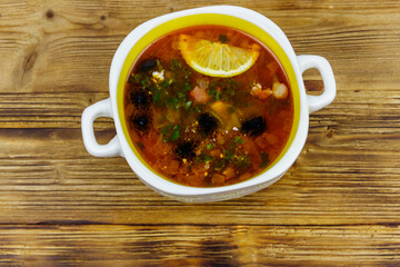 Traditional russian hodgepodge soup on a wooden table. Top view