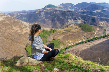 Naklejka na ściany i meble Young Woman Sitting above the Mountain with Stunning View .Pirin Mountain ,Bulgaria 