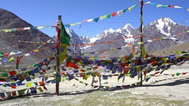 Buddhist Prayer Flags Blow By The Wind With Mountains In Background - wide shot