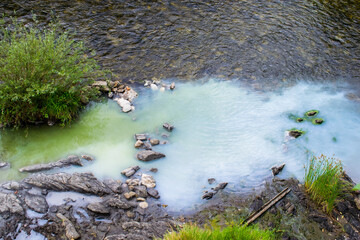 Thermal, sulphurous water flowing into the river. The water is whitish