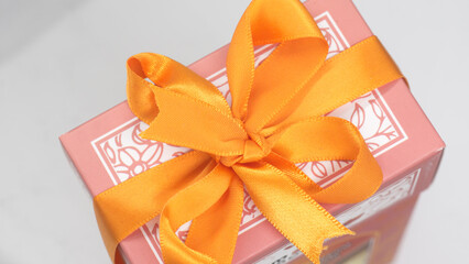 Pink gift box with orange bow for a fun holiday or birthday party