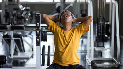 Old fit man inhale breathing in fitness gym