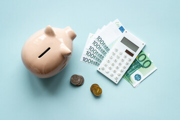 Finance and saving money concept. Piggy bank with cash money and calculator