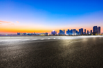 Obraz premium Empty asphalt road and modern city skyline in Hangzhou at sunrise,China.