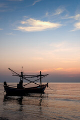 Naklejka premium Sunrise on the sea beach with fishing boat