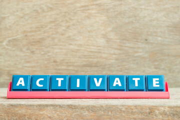 Obraz premium Tile alphabet letter with word activate in red color rack on wood background