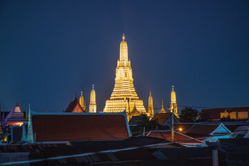 Naklejka premium Wat arun with roof top of the building in the night time.Wat Arun Ratchawararam Ratchawaramahawihan or Wat Arun is a Buddhist temple in Bangkok Yai district of Bangkok