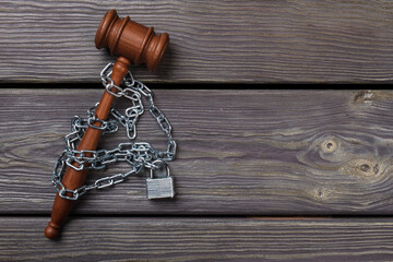 Court restrictions concept. Wooden gavel with padlock and chains.