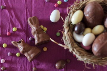 Fototapeta na wymiar Top view of chocolate bunnies and nest with easter eggs