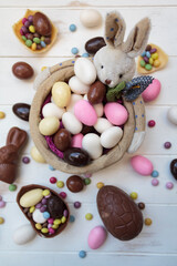 Top view of easter bunny basket with almonds, chocolate eggs and other easter sweets