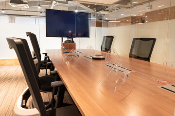 Obraz na płótnie Canvas Video conference meeting room with clear acrylic sheet separates the center on the conference table to prevent COVID-19 and face shield on the table. 