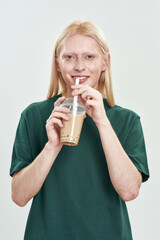 Happy young caucasian guy holding coffee beverage