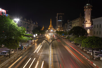 Fototapeta na wymiar Detail of night traffic towards Sule Pagoda Buddhist temple and stupa, from the Sule Paya Road Pedestrian Bridge, in long exposure photography.