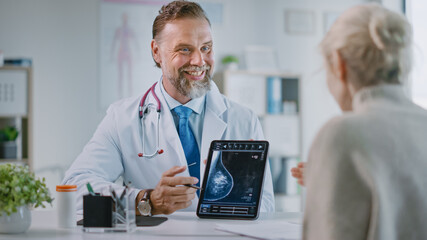 Fototapeta premium Family Medical Doctor Showing Mammography Test Results to a Senior Patient on a Tablet Computer in a Health Clinic. Friendly Assistant Explains Importance of Breast Cancer Prevention Screening.
