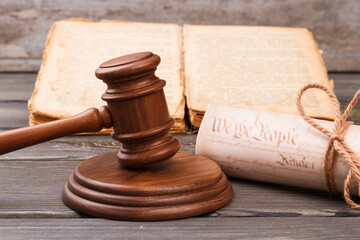 Retro court trial concept. Wooden gavel with book and scroll.