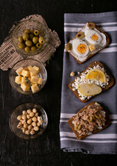 Sandwiches with different fillings. Ingredients: cream cheese, cottage cheese, eggs, olives, cheese, nuts, apple, lemon, salmon, thyme, black bread
