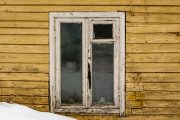 White wooden window on a background of an old yellow wooden wall