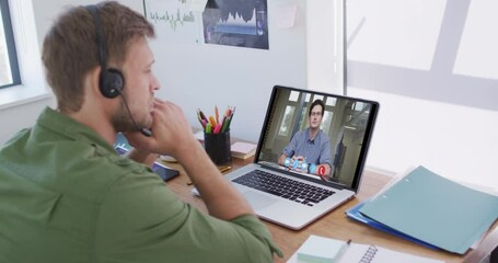 Caucasian man using laptop and phone headset on video call with male colleague