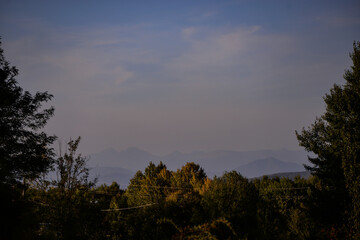 autumn landscape overlooking the horizon where the ridges of the high mountains can be seen. high hills full of dense forests