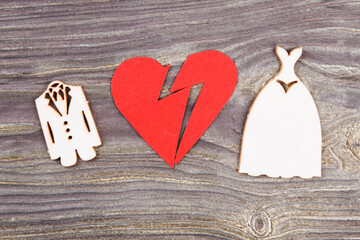 Divorce and canceling marriage concept. Broken heart and wedding dresses on wood.