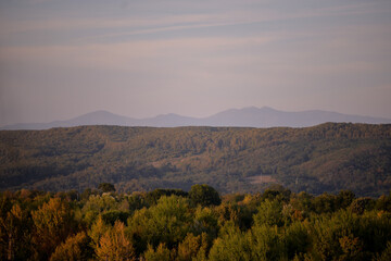 autumn landscape overlooking the horizon where the ridges of the high mountains can be seen. high hills full of dense forests