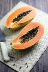 Pepaya or ripe papaya fruit one of tropical fruit in Indonesia. Cut into pieces on woven matt background. Close up view, copy space for text.
